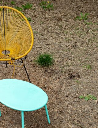 Lage draadstoel met laag tafeltje in de tuin