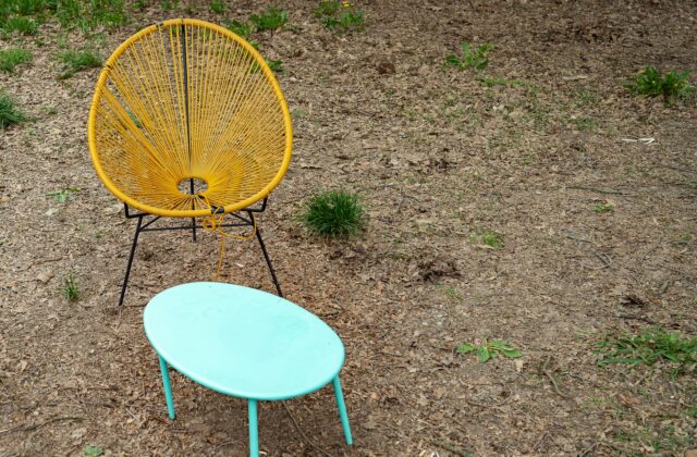 Lage draadstoel met laag tafeltje in de tuin