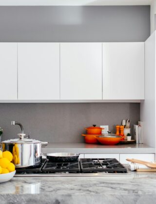Keuken met een lichtgrijs aanrechtblad en houten kastfronten