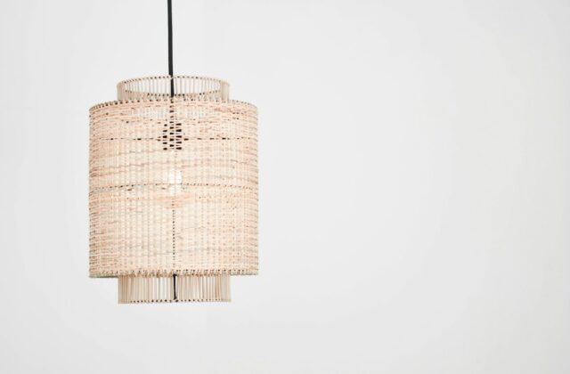 Hanglamp van bamboelatten boven een houten eettafel