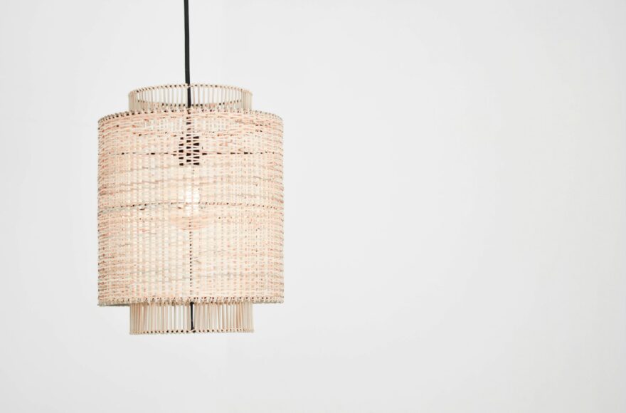 Hanglamp van bamboelatten boven een houten eettafel