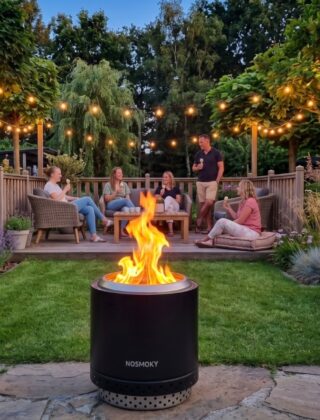 Zwarte rookvrije vuurkorf NoSmoky brandt op een gazon met mensen op het terras erachter