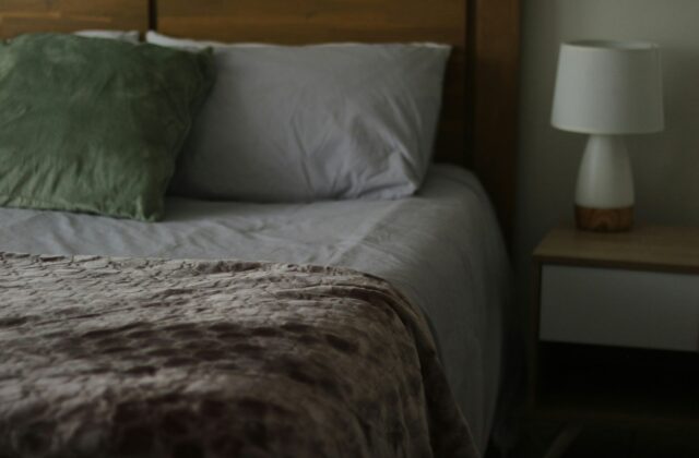 Opgemaakt bed met flanellen dekbedovertrek en wollen plaid in een slaapkamer