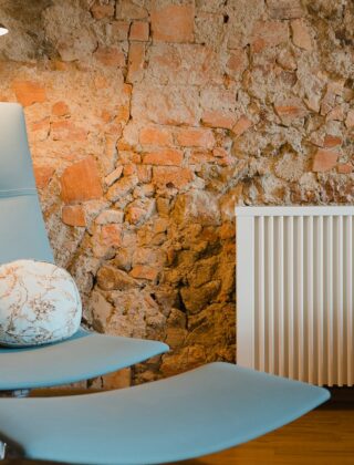 Een zwarte verticale designradiator aan de muur van een woonkamer