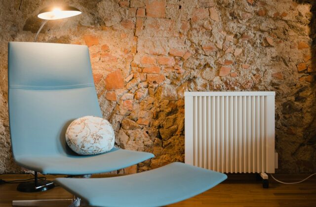 Een zwarte verticale designradiator aan de muur van een woonkamer