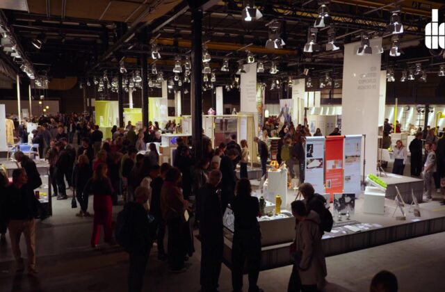 Bezoekers lopen tussen ontwerppresentaties in een industriële hal tijdens Dutch Design Week in Eindhoven