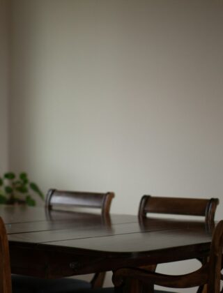 Een houten eettafel met stoelen in een lichte eetkamer