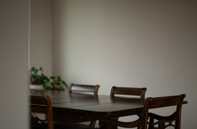 Een houten eettafel met stoelen in een lichte eetkamer
