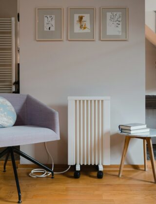 Woonkamer met bank en een elektrische kachel naast een houten bijzettafel