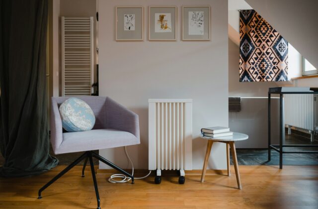 Woonkamer met bank en een elektrische kachel naast een houten bijzettafel
