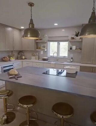 Opgeknapte keuken met kookeiland, grijs werkblad en gouden barkrukken uit de serie Totally '90s House