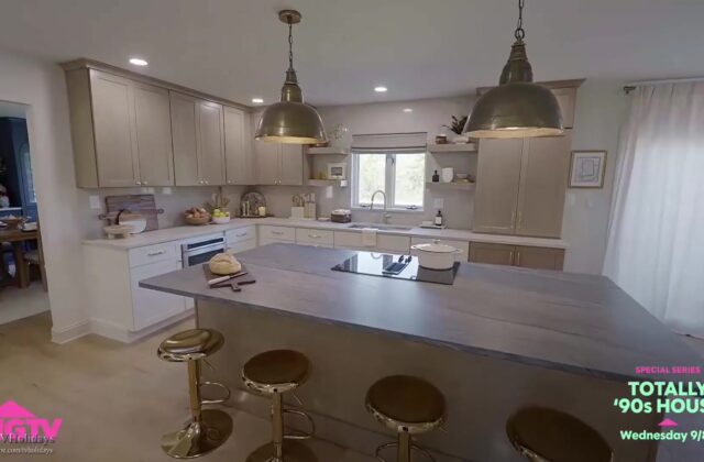 Opgeknapte keuken met kookeiland, grijs werkblad en gouden barkrukken uit de serie Totally '90s House