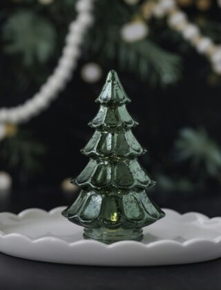 Een groene keramieken kerstboom met gekleurde lichtjes