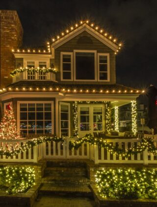 Warmwitte kerstverlichting in een boom voor een bakstenen huis in de avond
