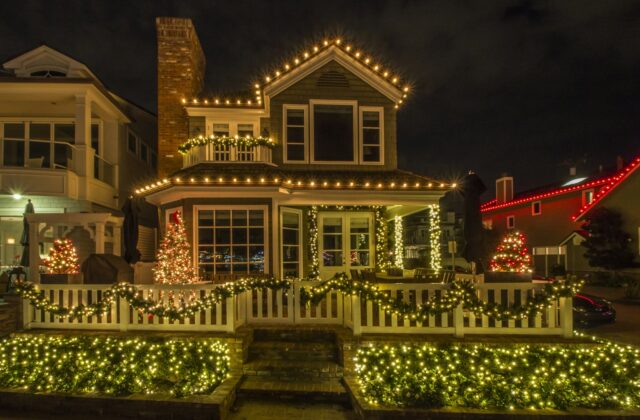 Warmwitte kerstverlichting in een boom voor een bakstenen huis in de avond