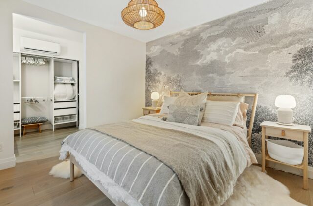 Slaapkamer met een wand bekleed met gestreepte linnen stof