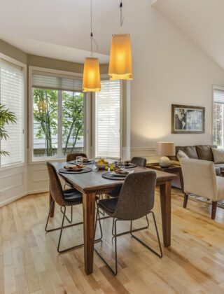 Warme woonkamer met houten vloer, losse meubels en een staande lamp in een huurwoning