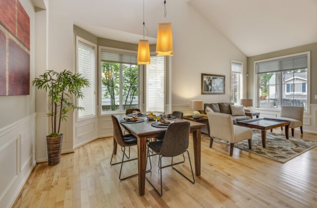 Warme woonkamer met houten vloer, losse meubels en een staande lamp in een huurwoning