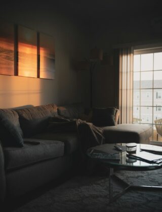 Woonkamer in de avond met tafellamp, vloerlamp en warm licht in lagen