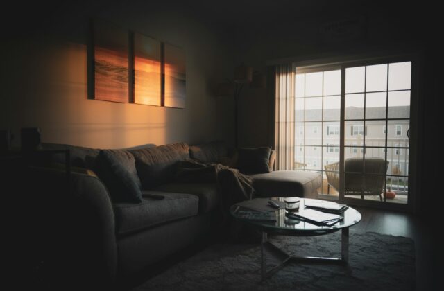 Woonkamer in de avond met tafellamp, vloerlamp en warm licht in lagen