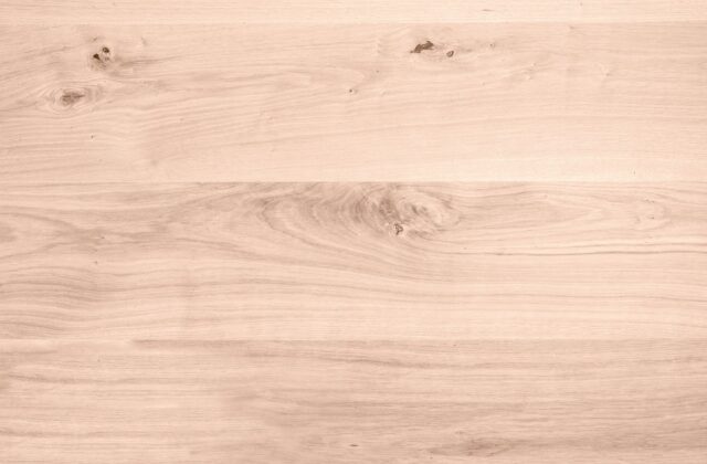 Lichte woonkamer met een houten vloer en grote ramen